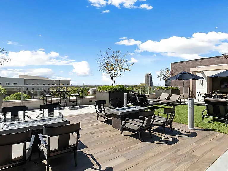 Rooftop Lounge Area With Fire Pits, Seating, and Shade Umbrellas