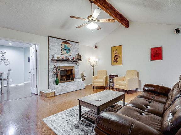 Living room has wood burning fire place and ample seating.