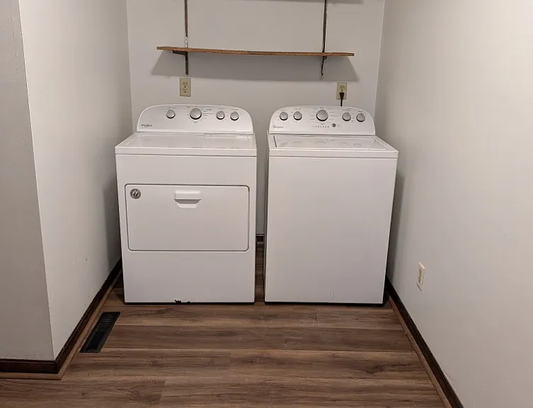 Private laundry utility room with included washer and dryer.