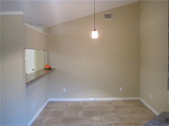This is a view of the dining room. There is a breakfast bar to the kitchen on the left. This room ha