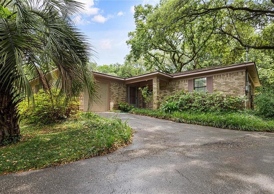 View of front facade featuring an attached garage, aphalt driveway, and brick siding