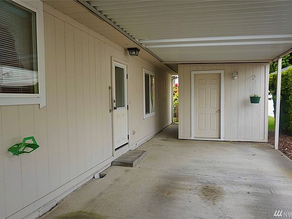 Mud room/laundry room entrance through carport.