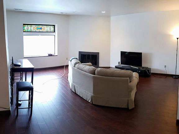 Large living room with hardwood floors, fireplace and lots of natural light