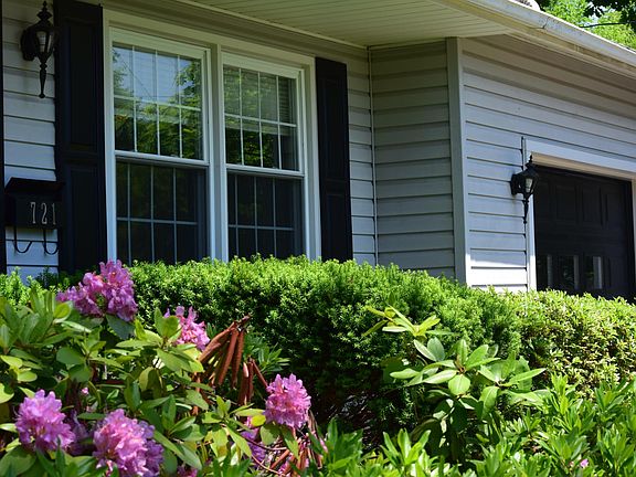 Multiple hydrangea bushes surround the front and back of the home.