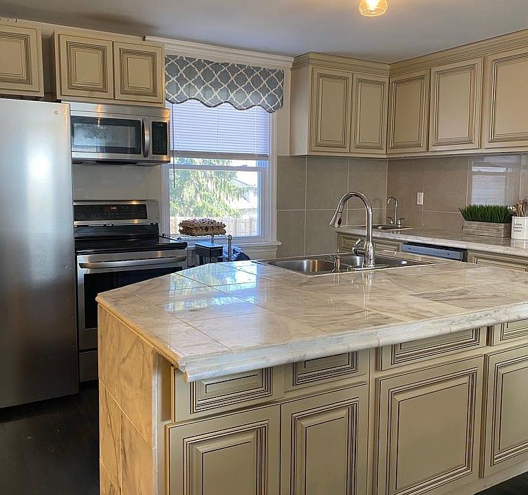 Kitchen w/ island, two sinks, range, dishwasher, microwave, disposal.
