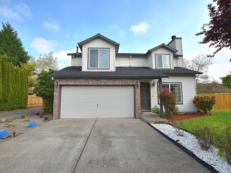 House front view with white marble decoration, a double parking garage, a 2-car parking driveway, and ample parking space on the roadside.