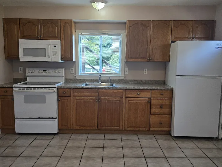 Kitchen with brand new refrigerator, electric stove and microwave