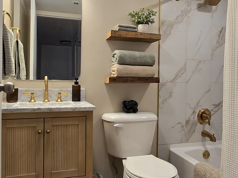 Fully renovated guest bathroom featuring modern finishes and a tub/shower combo.