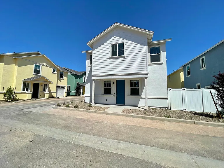 View of single family home with side gate entrance to backyard.