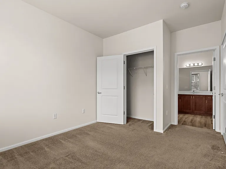 Comfortable bedroom featuring a walk-in closet and convenient access to a private bathroom. Comfortable bedroom featuring a walk-in closet and convenient access to a private bathroom.