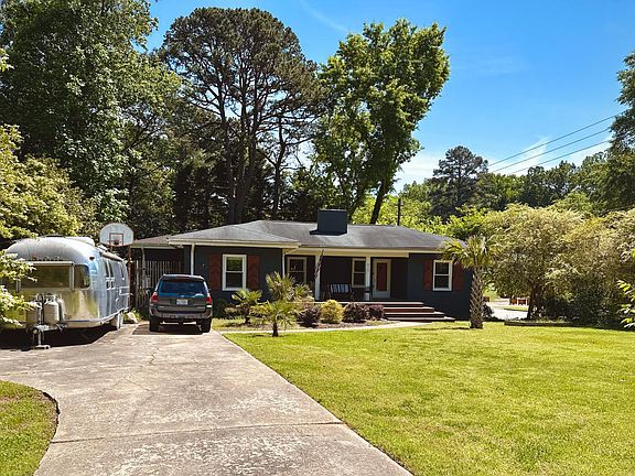 Entrance to 915 Lake Boone Trail's main driveway for complimentary off-street parking. 1973 Airstream Ambassador parked on right side currently.