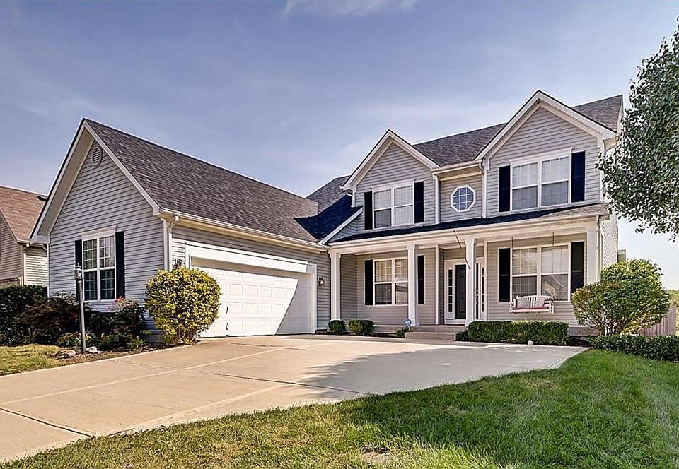 Front elevation features covered porch with swing and side-load garage.