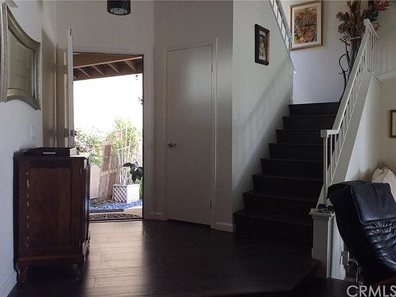 Looking at the raised entry, wood flooring and wooden stairs. Two steps down. Modified from original