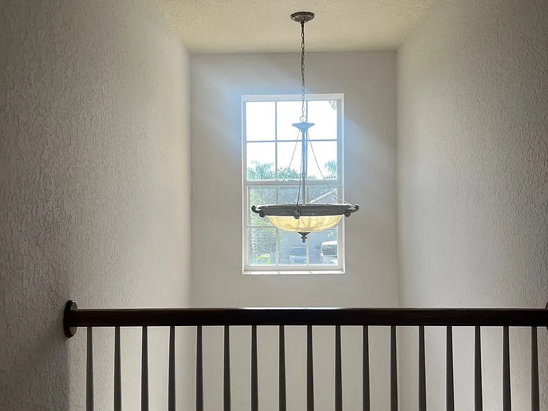 73 - Upper hallway with window and staircase railing.