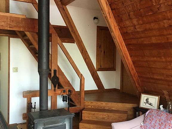 View of living room and steps to loft