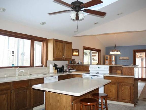 Opposite view showing the Corian countertops, large island, and the open layout. The flooring was updated in 2010. Fantastic views from every window!