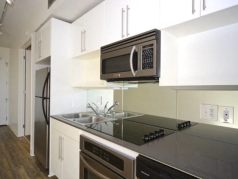 Kitchen with easy clean range top white cabinets at 12th Street Lofts in National City, California.