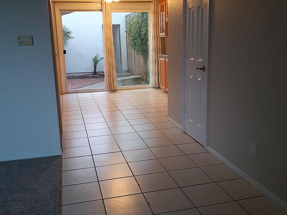 Empty view from front entrance to back patio thru dining and out to the detached 2 car garage