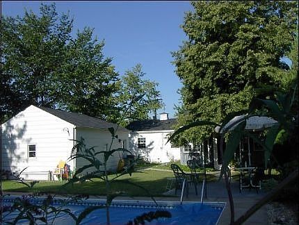 a portion of the inground swimming pool in the beautifully landscaped yard
