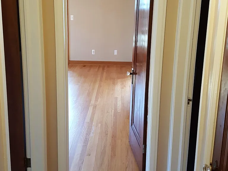 hallway from 2x bedrooms to living room. Bath left, kitchen and upstairs right