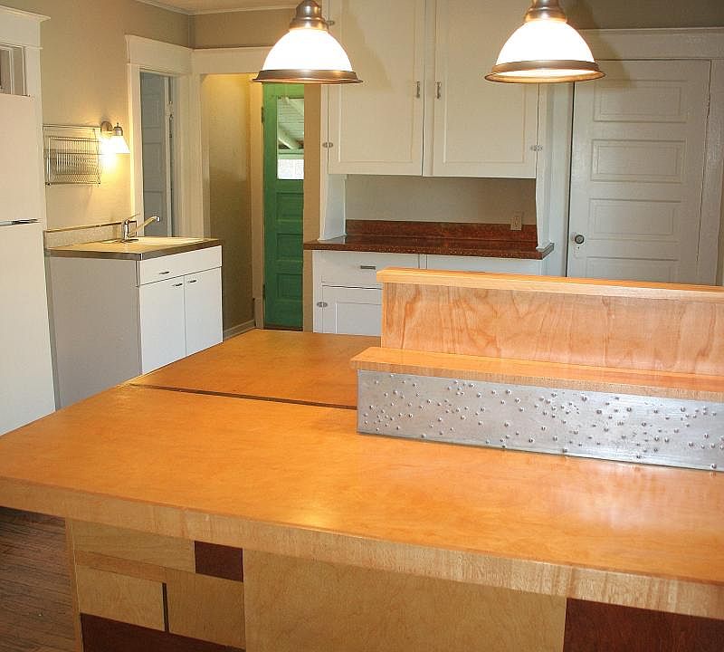 very large kitchen with copper counter tops and bar.
