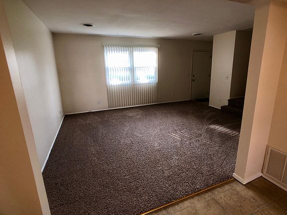 Large living room with new carpeting and blinds