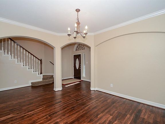 The formal dining room is spacious and has a pretty wall niche for a special piece of furniture. The hardwoods continue through the downstairs living area.