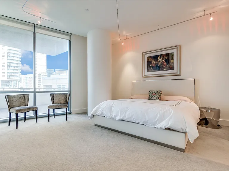 Bedroom with expansive windows, carpet flooring, and track lighting