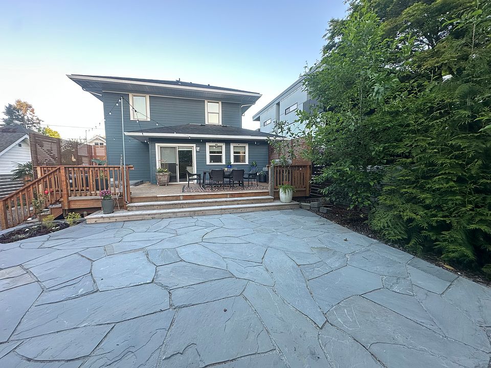 Back yard, deck, and patio. No grass, just stone patio and mulch beds.