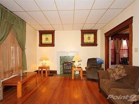The living room is large, with wood floors a beautiful fireplace and stained glass windows.