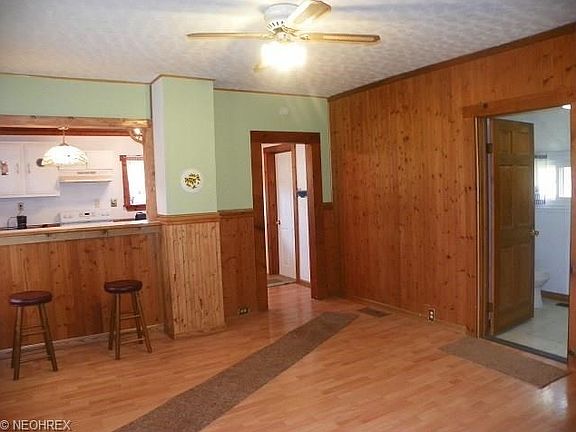 Knotty pine dining room with new laminate floor  has set up for woodstove for additional heat option   side bar set up too