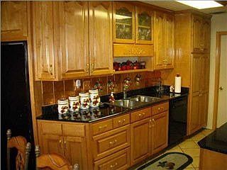 Kitchen has custom cabinets, granite counters, pantry with pull-out shelves.