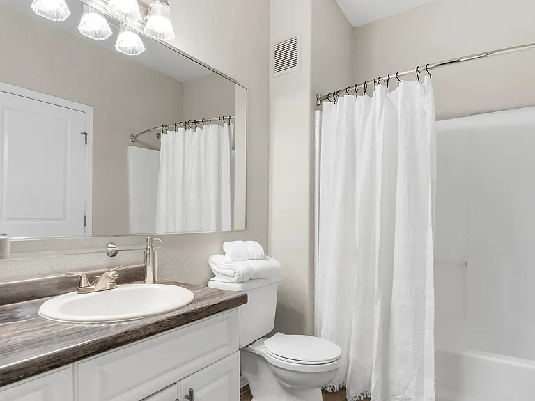 Luxuriate in a bathroom with a spacious, well-lit vanity area.