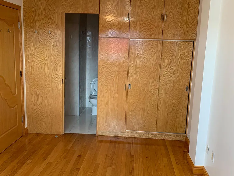 Custom made wooden closet and cabinet, and slide door entrance to the bathroom