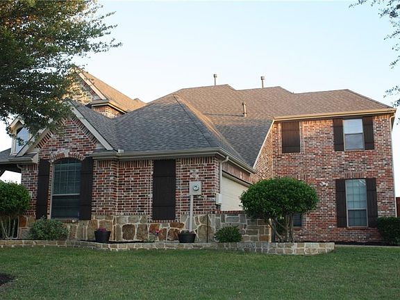 The large interior corner lot features a three-car garage that is accessed from the side street, which allows for a large front and back yard.