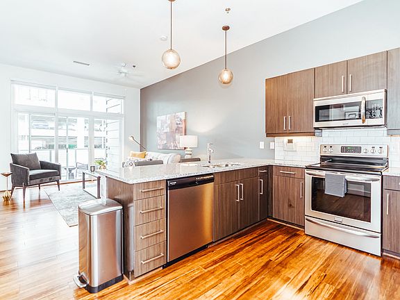 Modern Kitchen with Stainless Steel Appliances, Quartz Countertops, and Wood-Designed Floors