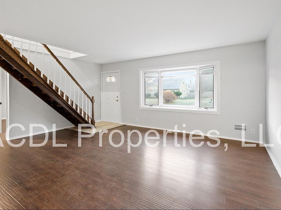 Large living room with hardwood floors and large windows.