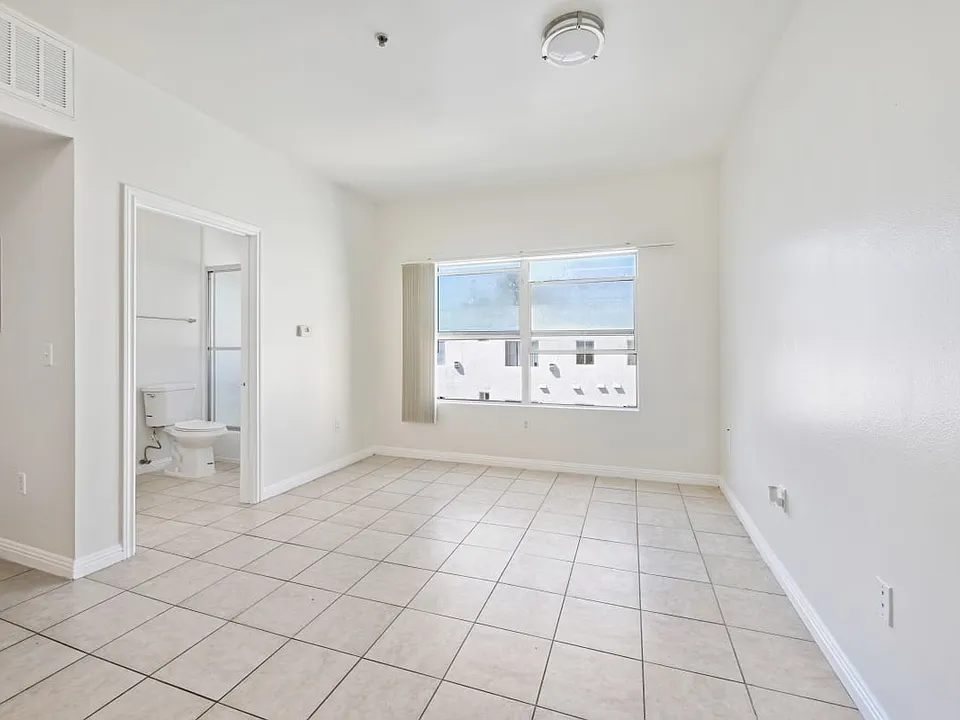 Burlington a bedroom with a tiled floor and a large window