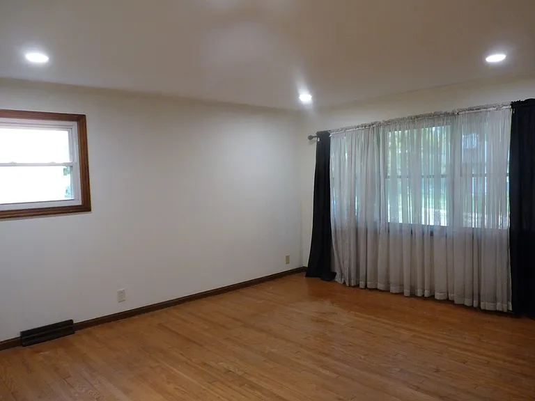 living room with large picture window and warm hardwood floors