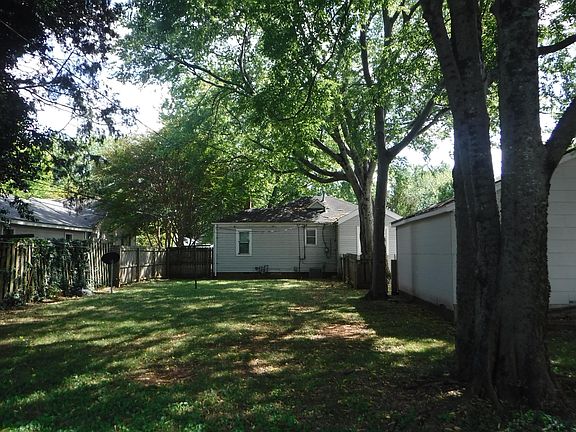Picture taken from rear of back yard looking at house. Two car garage on right - access from Rhett only. Fully fenced-in, shady backyard.