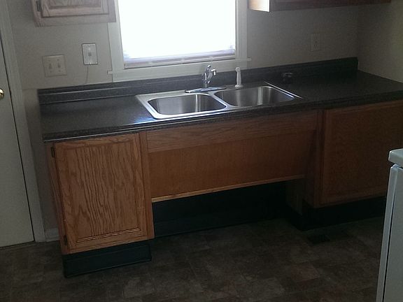 black countertops, electric stove and new flooring