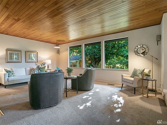 Standing in the foyer, you will immediately sense the beauty of the intricacies of the home such as the captivating wood ceilings and large picture windows which over look the private back yard!