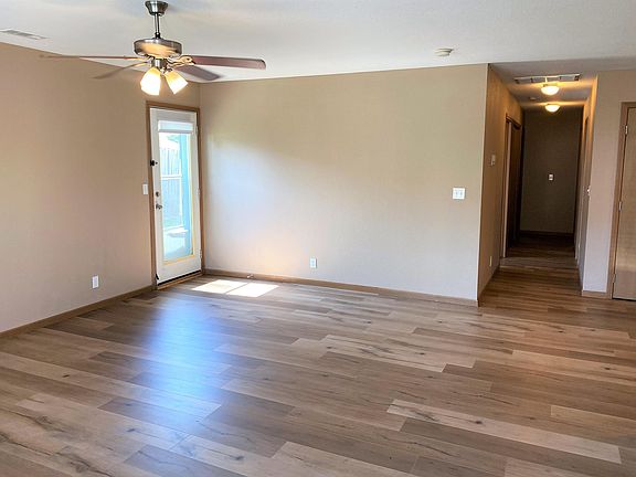 LR FROM FRONT DOOR. FRENCH DOOR OPENS TO PATIO. HALLWAY TO BATHROOM #1, LAUNDRY AREA AND 3 BEDROOMS