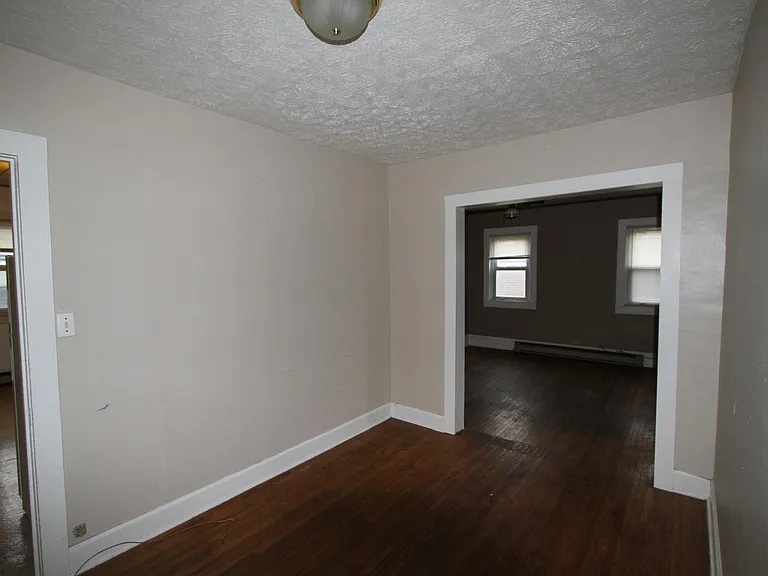 View from Dining room to Living room. Kitchen on left, bedroom 1 on right