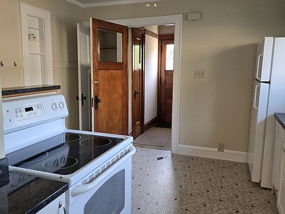 Kitchen with view of back entrance and door to stairwell and balcomy