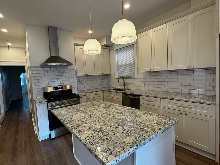 Kitchen (Actual Picture): Spacious kitchen featuring a large granite island with seating for two, abundant cabinet storage, subway tile backsplash, stainless steel appliances, gas range, dishwasher, and a generous walk-in pantry.