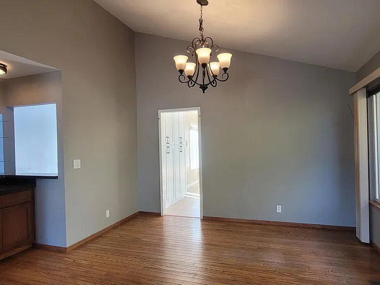 Bright dining area with large windows overlooking the backyard and a built-in wet bar.
