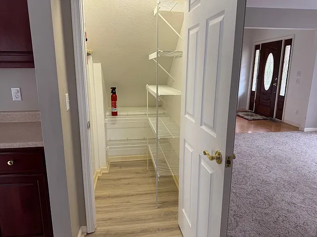 Kitchen storage with view of dinning room and front door.