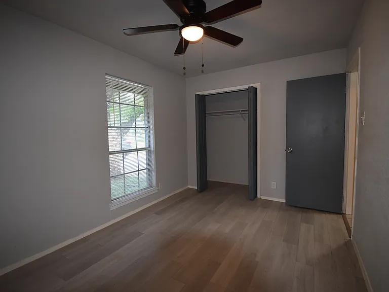 Primary bedroom features a new ceiling fan and a large window.