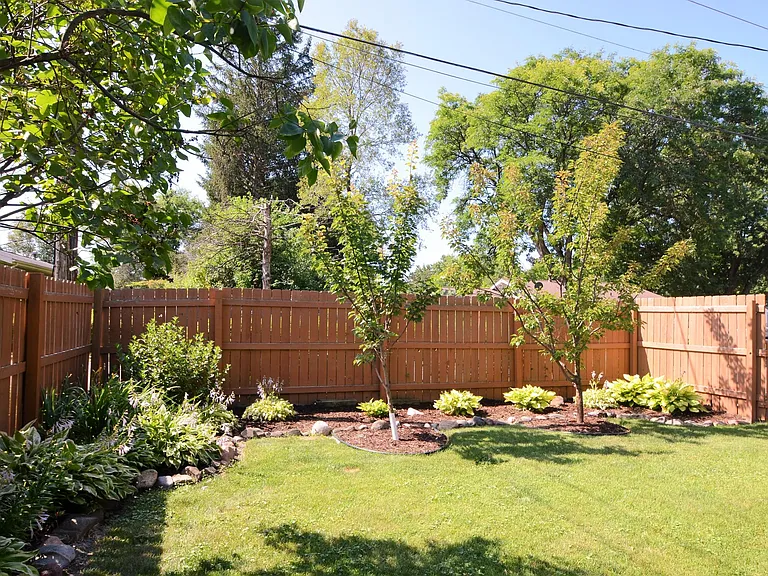 Flower gardens, flowering apricot trees. Privacy fence.